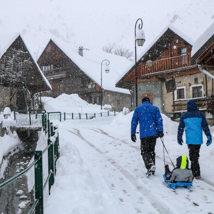 Promeneurs sous la neige dans les rues du village