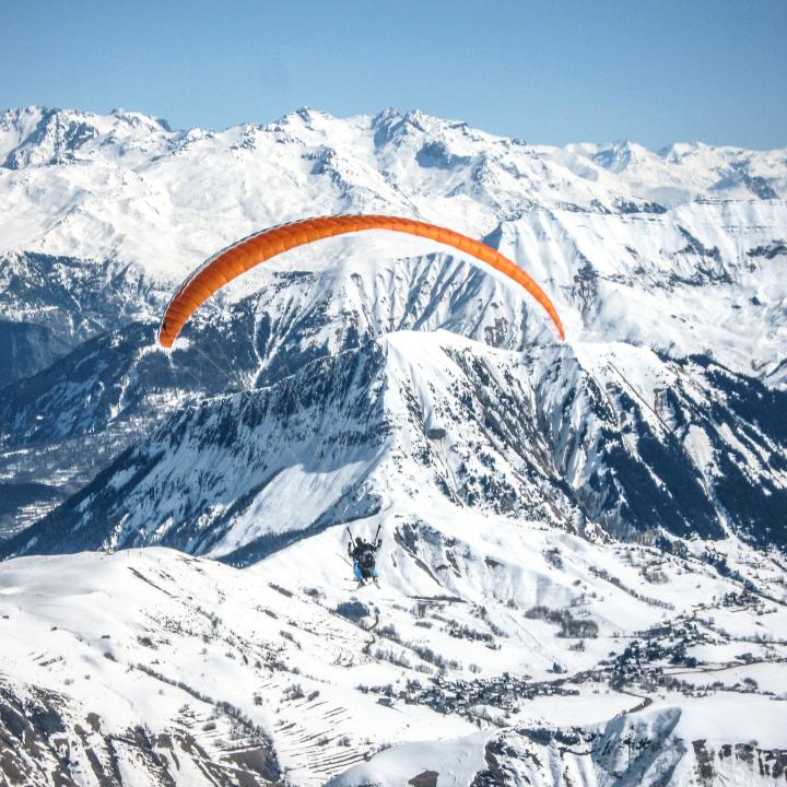 Parapente au-dessus des montagnes enneigées