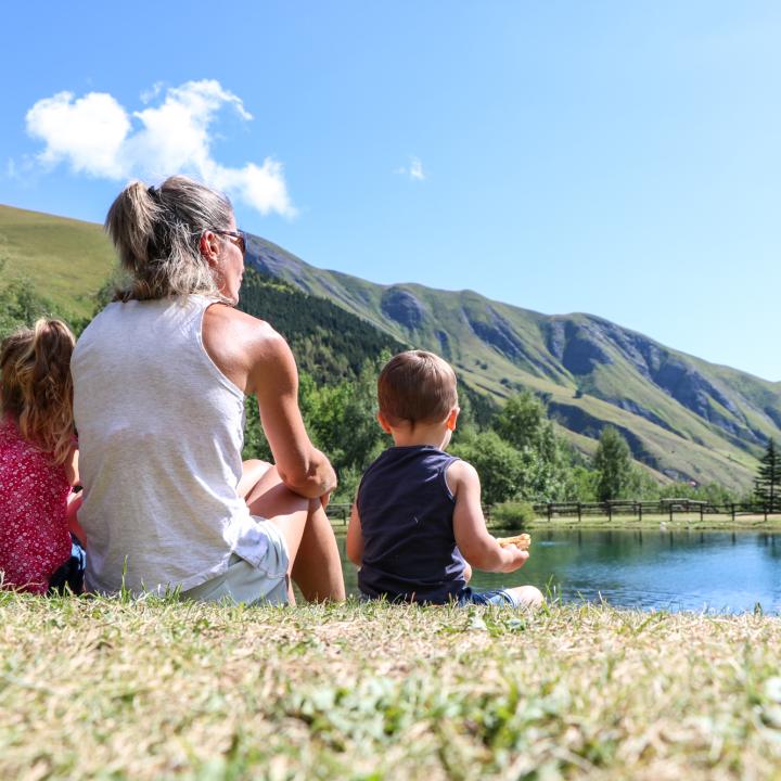 Famille assise au bord du plan d'eau