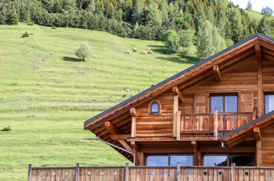Chalet en bois devant la montagne en été