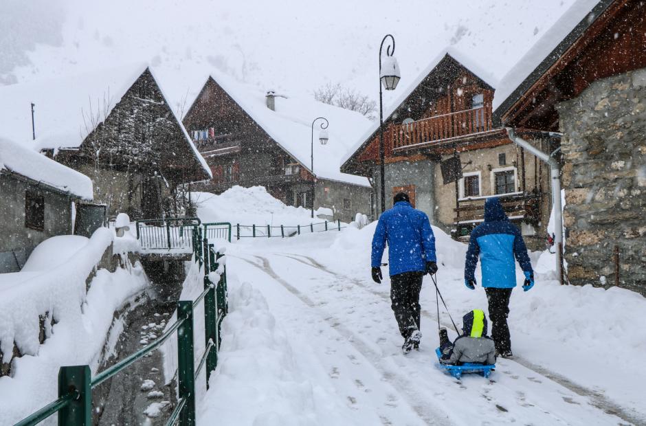 Promeneurs sous la neige dans les rues du village