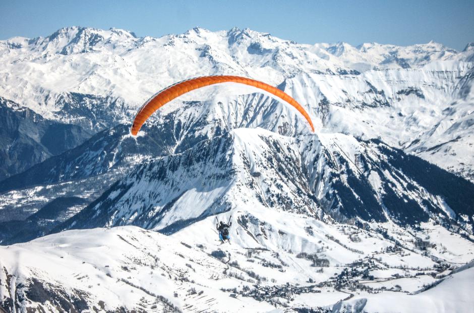 Parapente au-dessus des montagnes enneigées