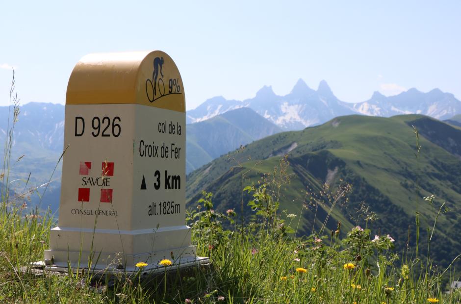 Borne du Col de la Croix de Fer avec les Aiguilles d'Arves en fond