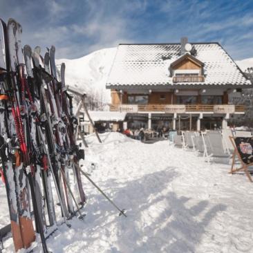 Restaurant Les Cèdres - Vue extérieure avec transats ski aux pieds